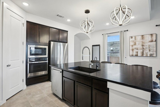 8119 Purple Aster Pass, Leander, TX 78645 - kitchen with appliances with stainless steel finishes, a chandelier, dark countertops, dark brown cabinets, and decorative light fixtures