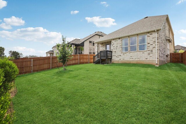 8119 Purple Aster Pass, Leander, TX 78645 - back of property featuring a fenced backyard, brick siding, and roof with shingles