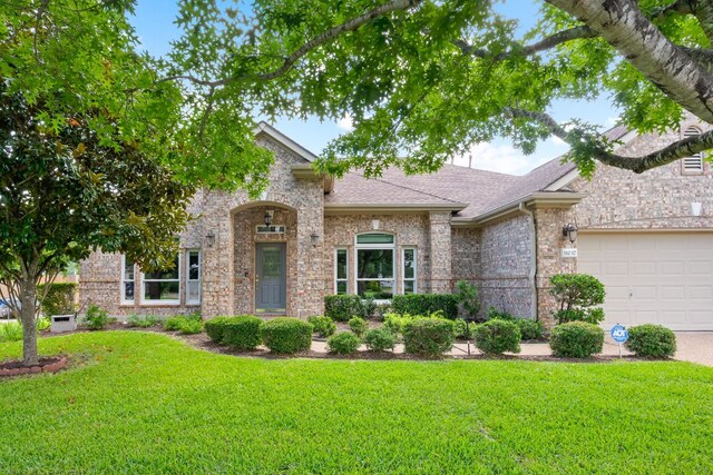 11037 River Plantation Dr, Austin, TX 78747 - view of front facade featuring a front yard, an attached garage, a shingled roof, and brick siding