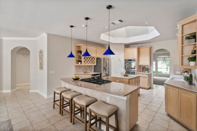 11037 River Plantation Dr, Austin, TX 78747 - kitchen with open shelves, arched walkways, appliances with stainless steel finishes, light brown cabinets, and a kitchen island