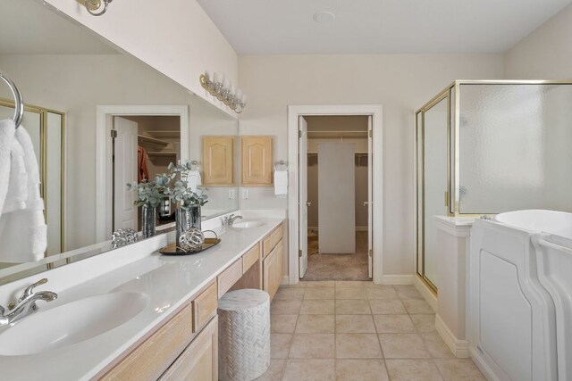 11037 River Plantation Dr, Austin, TX 78747 - bathroom with a spacious closet, a stall shower, double vanity, tile patterned flooring, and washer / dryer