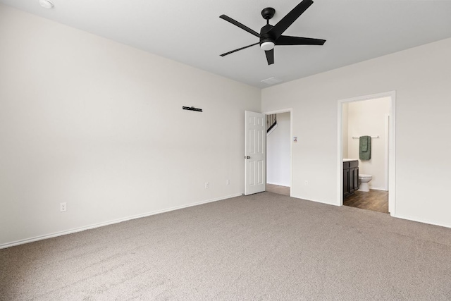 709 Hummingbird Ln, Leander, TX 78641 - unfurnished bedroom featuring dark carpet, connected bathroom, baseboards, and a ceiling fan