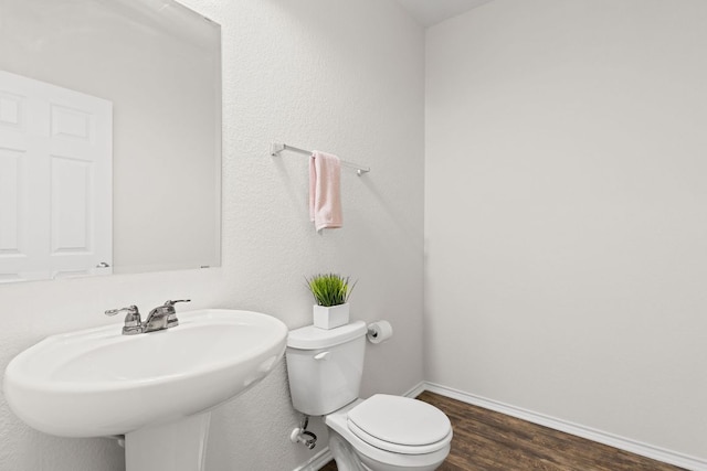 709 Hummingbird Ln, Leander, TX 78641 - bathroom featuring wood finished floors, toilet, and baseboards