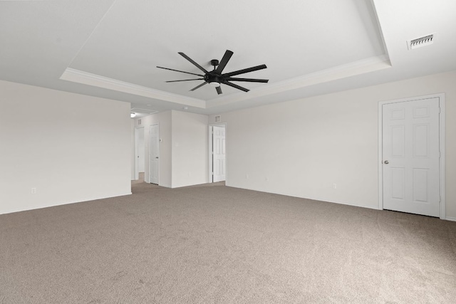 709 Hummingbird Ln, Leander, TX 78641 - carpeted spare room featuring a tray ceiling, ornamental molding, and a ceiling fan