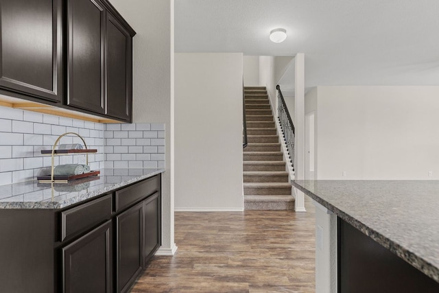 709 Hummingbird Ln, Leander, TX 78641 - kitchen featuring wood finished floors, backsplash, baseboards, and dark brown cabinets