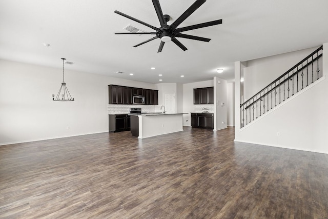 709 Hummingbird Ln, Leander, TX 78641 - unfurnished living room featuring dark wood-type flooring, a ceiling fan, baseboards, recessed lighting, and stairs