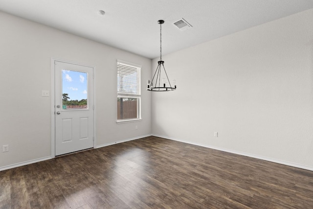 709 Hummingbird Ln, Leander, TX 78641 - unfurnished dining area with a chandelier, dark wood-style flooring, and baseboards