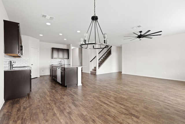 709 Hummingbird Ln, Leander, TX 78641 - kitchen with open floor plan, dark wood-type flooring, decorative backsplash, recessed lighting, and a center island with sink