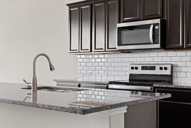 709 Hummingbird Ln, Leander, TX 78641 - kitchen with stainless steel appliances, a sink, dark stone countertops, and backsplash