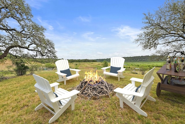 409 Lake View Dr, Spicewood, TX 78669 - view of grassy yard featuring an outdoor fire pit and a rural view