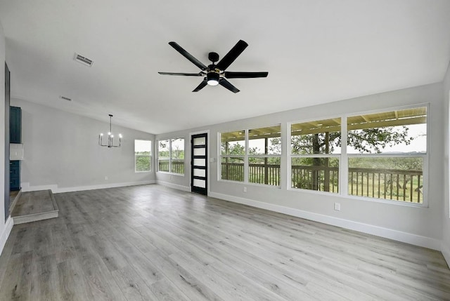 409 Lake View Dr, Spicewood, TX 78669 - unfurnished living room with a chandelier, baseboards, vaulted ceiling, a ceiling fan, and wood finished floors