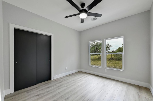 409 Lake View Dr, Spicewood, TX 78669 - unfurnished bedroom featuring baseboards, light wood-type flooring, ceiling fan, and a closet