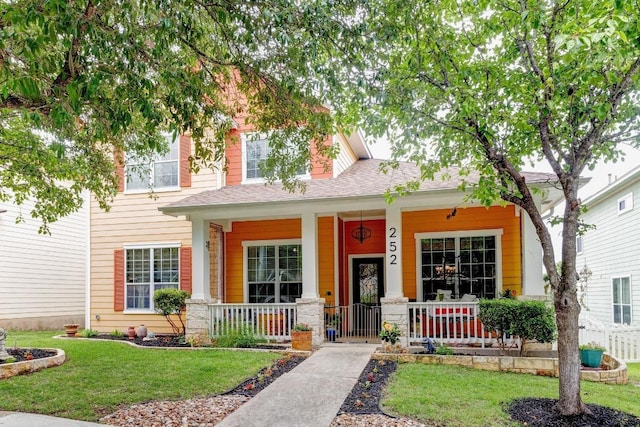 252 Hutton, Kyle, TX 78640 - view of front facade featuring covered porch, a front yard, and a shingled roof