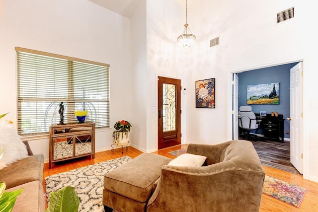 252 Hutton, Kyle, TX 78640 - living area featuring a high ceiling, wood finished floors, baseboards, and a chandelier