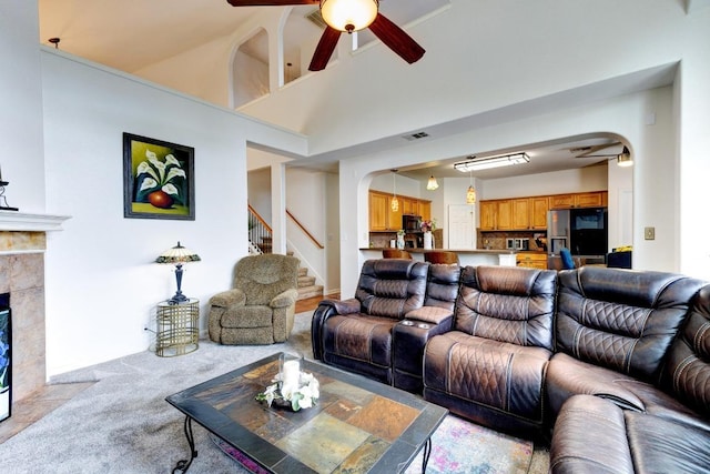 252 Hutton, Kyle, TX 78640 - living room with arched walkways, light carpet, a ceiling fan, and stairway