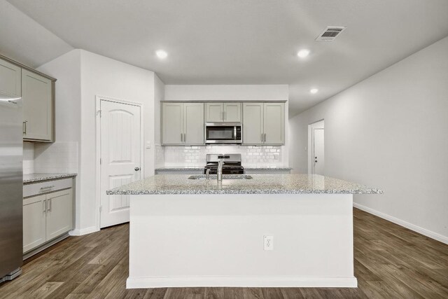 210 Briggs Ln, San Marcos, TX 78666 - kitchen featuring appliances with stainless steel finishes, gray cabinets, tasteful backsplash, dark wood-type flooring, and recessed lighting