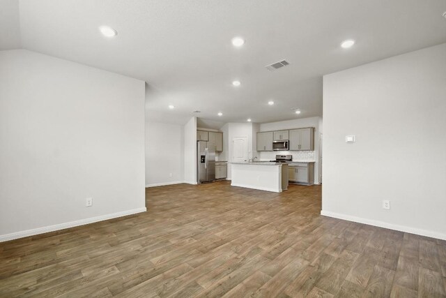 210 Briggs Ln, San Marcos, TX 78666 - unfurnished living room with recessed lighting, wood finished floors, and baseboards