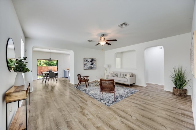 14605 Naruna Way, Pflugerville, TX 78660 - living area with arched walkways, wood finished floors, a ceiling fan, and baseboards