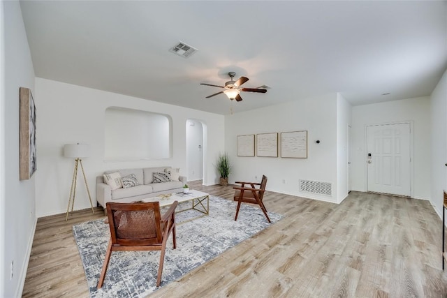14605 Naruna Way, Pflugerville, TX 78660 - living room with arched walkways, wood finished floors, a ceiling fan, and baseboards