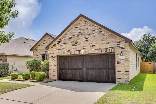 14605 Naruna Way, Pflugerville, TX 78660 - view of front of home with an attached garage, brick siding, driveway, and a front lawn