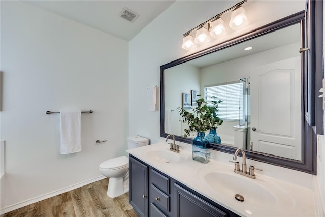 14605 Naruna Way, Pflugerville, TX 78660 - bathroom featuring toilet, double vanity, wood finished floors, and baseboards