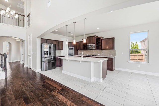 505 Fair Oaks Dr, Georgetown, TX 78628 - kitchen with stainless steel appliances, arched walkways, open shelves, a chandelier, and light countertops