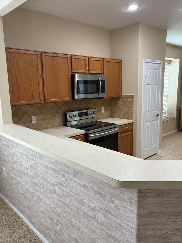 127 Nassau Cir, Georgetown, TX 78633 - kitchen with appliances with stainless steel finishes, brown cabinets, backsplash, light countertops, and recessed lighting