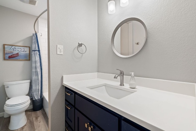 515 Circle Dr, Sunrise Beach, TX 78643 - full bath featuring vanity, wood finished floors, toilet, shower / bath combination with curtain, and a textured wall
