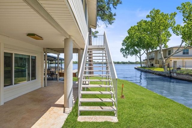 515 Circle Dr, Sunrise Beach, TX 78643 - view of green lawn featuring stairs, a water view, and a patio area
