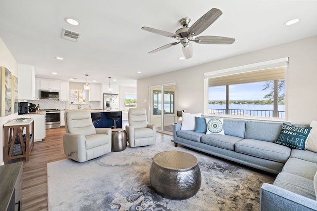 515 Circle Dr, Sunrise Beach, TX 78643 - living room with wood finished floors, recessed lighting, ceiling fan, and a water view