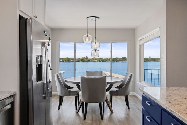 515 Circle Dr, Sunrise Beach, TX 78643 - dining space featuring light wood-style floors, baseboards, and a water view