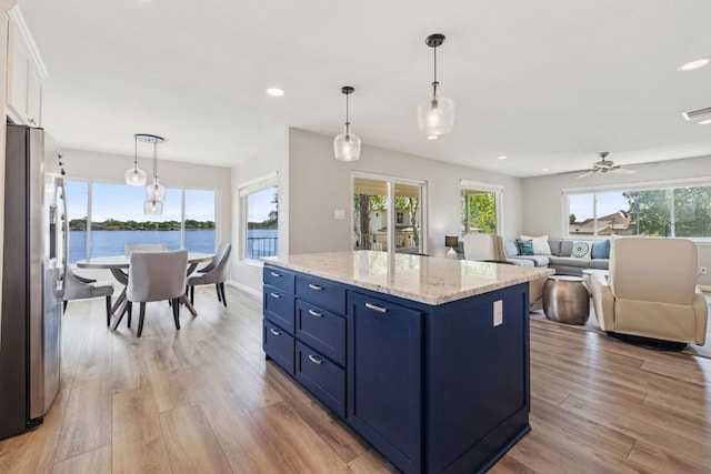 515 Circle Dr, Sunrise Beach, TX 78643 - kitchen with stainless steel fridge with ice dispenser, blue cabinets, light wood-style flooring, plenty of natural light, and recessed lighting