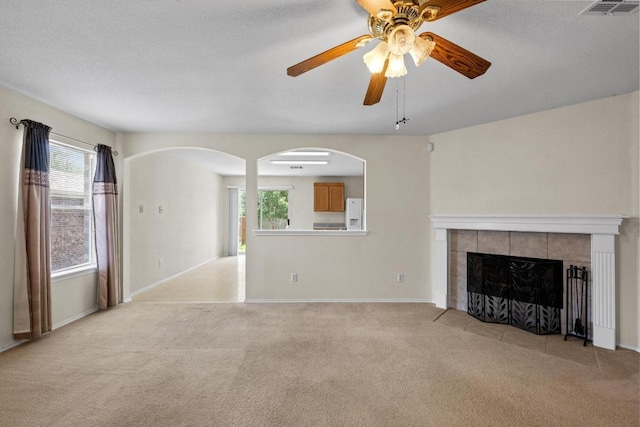 3807 Haleys Way, Round Rock, TX 78665 - unfurnished living room featuring light colored carpet, a ceiling fan, arched walkways, and plenty of natural light
