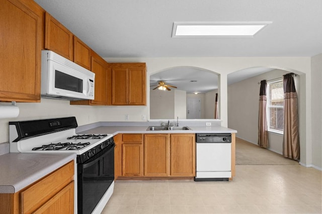 3807 Haleys Way, Round Rock, TX 78665 - kitchen featuring white appliances, arched walkways, light countertops, a sink, and a ceiling fan