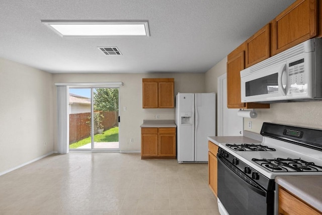 3807 Haleys Way, Round Rock, TX 78665 - kitchen featuring white appliances, brown cabinetry, and light countertops
