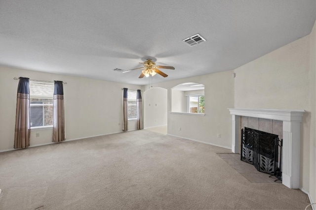 3807 Haleys Way, Round Rock, TX 78665 - unfurnished living room with a ceiling fan, a fireplace, light carpet, baseboards, and a textured ceiling