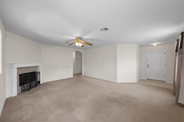 3807 Haleys Way, Round Rock, TX 78665 - unfurnished living room with light colored carpet, a ceiling fan, arched walkways, and a fireplace