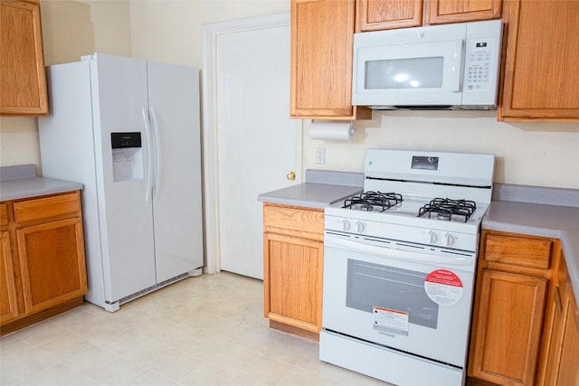 3807 Haleys Way, Round Rock, TX 78665 - kitchen with white appliances, light countertops, and brown cabinetry