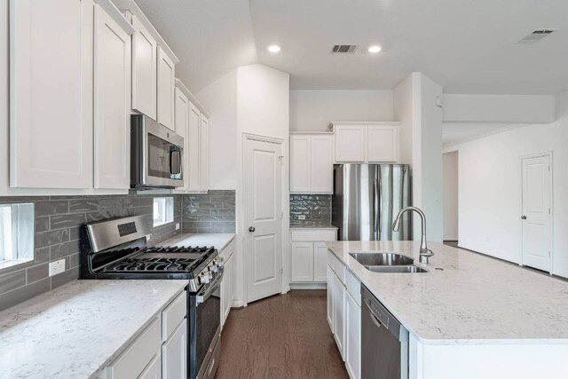231 Prato Pl, Georgetown, TX 78628 - kitchen featuring appliances with stainless steel finishes, a kitchen island with sink, white cabinets, backsplash, and recessed lighting