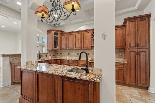 800 Canyon Bend Rd, Pflugerville, TX 78660 - kitchen featuring a sink, light stone counters, brown cabinetry, glass insert cabinets, and recessed lighting