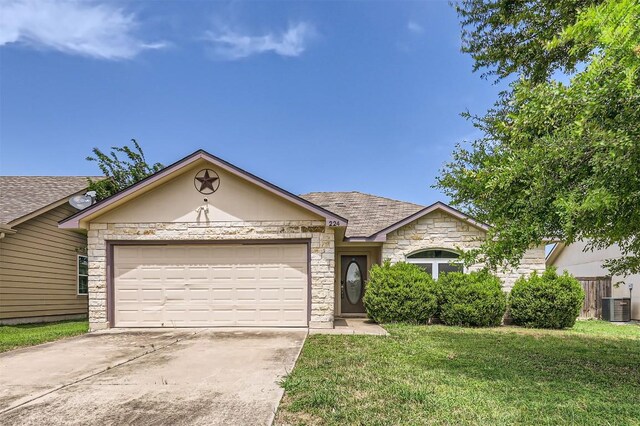 224 Copper Ln, Jarrell, TX 76537 - ranch-style home featuring stone siding, cooling unit, concrete driveway, a garage, and a front yard