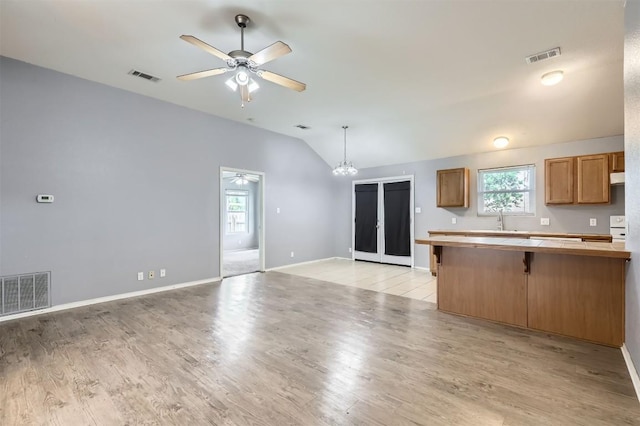 224 Copper Ln, Jarrell, TX 76537 - kitchen featuring a ceiling fan, vaulted ceiling, a breakfast bar, light wood-style flooring, and healthy amount of natural light