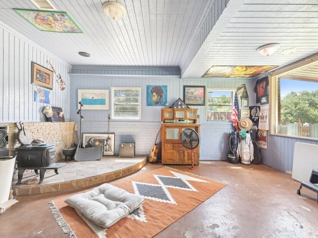 8622 Thunderbird Rd, Austin, TX 78736 - sitting room featuring unfinished concrete floors, a wood stove, and wooden ceiling