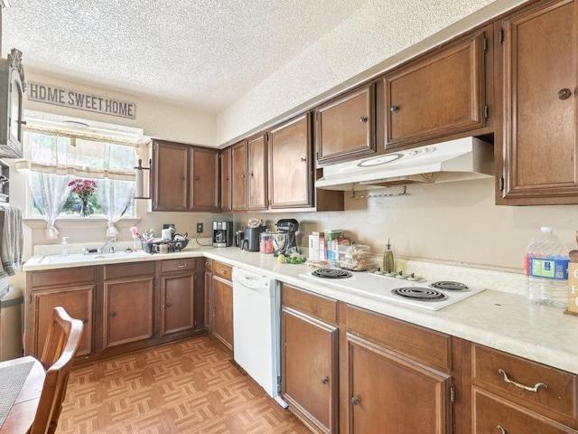 8622 Thunderbird Rd, Austin, TX 78736 - kitchen featuring under cabinet range hood, white appliances, a textured ceiling, light countertops, and a sink