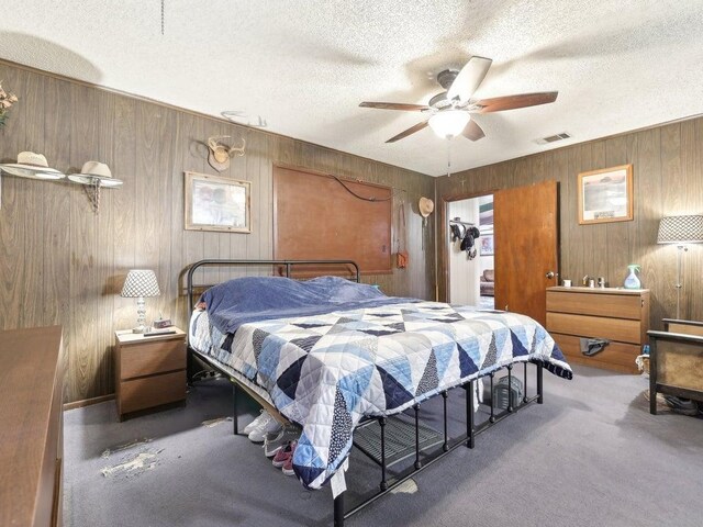 8622 Thunderbird Rd, Austin, TX 78736 - carpeted bedroom with wood walls, a textured ceiling, and ceiling fan
