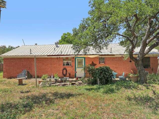8622 Thunderbird Rd, Austin, TX 78736 - rear view of property featuring brick siding, metal roof, and a yard