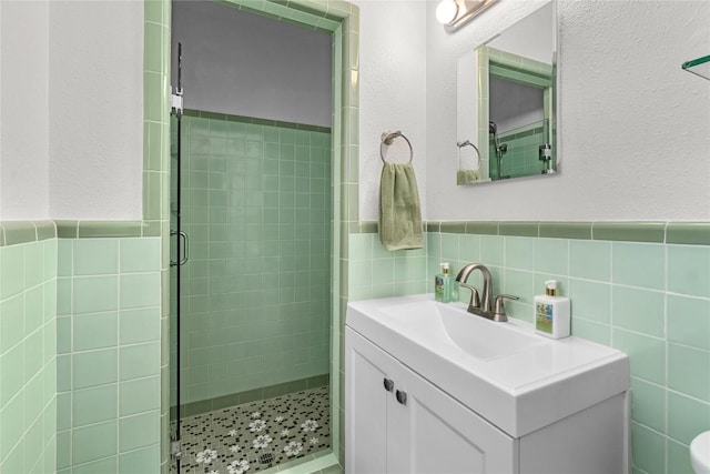 2301 Del Curto Rd, Austin, TX 78704 - full bathroom featuring a shower stall, tile walls, vanity, and a wainscoted wall