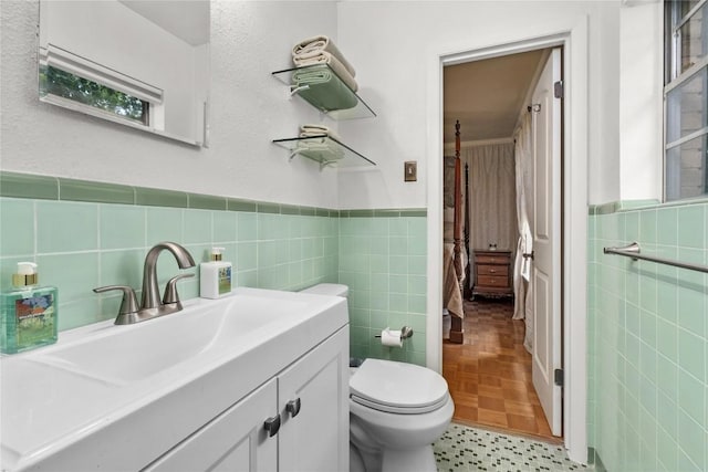 2301 Del Curto Rd, Austin, TX 78704 - bathroom with tile walls, toilet, vanity, and a wainscoted wall