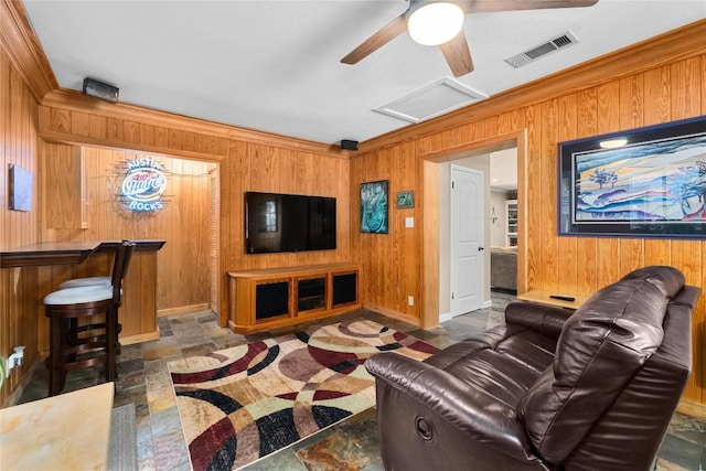 2301 Del Curto Rd, Austin, TX 78704 - living area featuring wood walls, ceiling fan, baseboards, stone finish floors, and ornamental molding