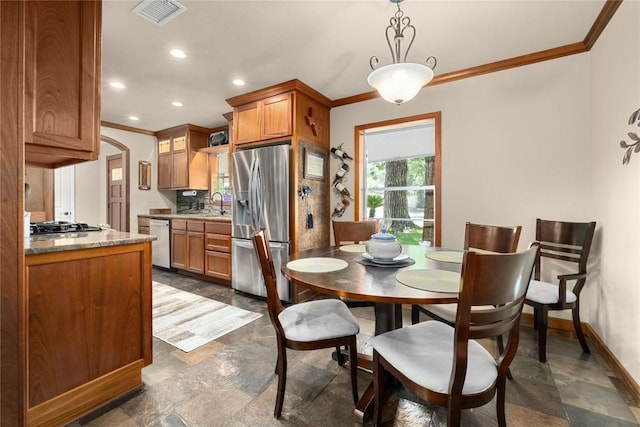 2301 Del Curto Rd, Austin, TX 78704 - dining area with crown molding, baseboards, arched walkways, recessed lighting, and dark stone finish floors